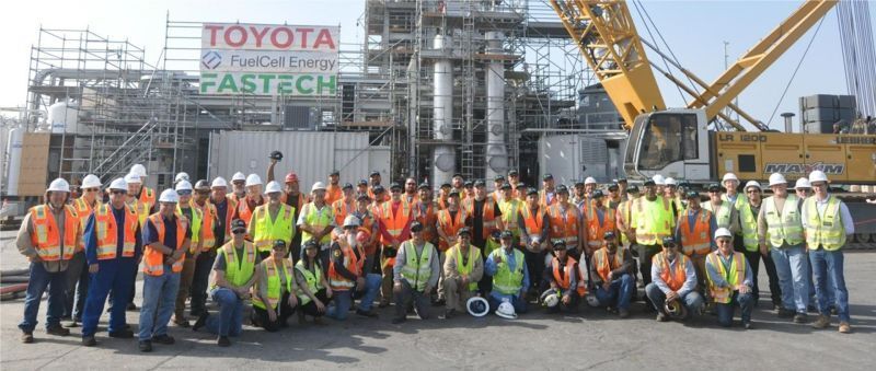 Construction team in front of the Long Beach Tri-gen plant with Toyota, FuelCell Energy, and FASTECH signs